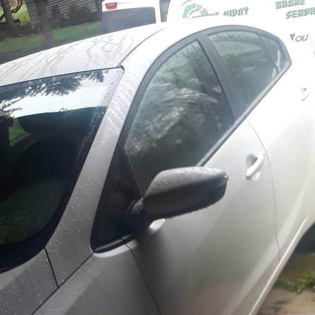 Customer Kia Forte photographed beside the work area